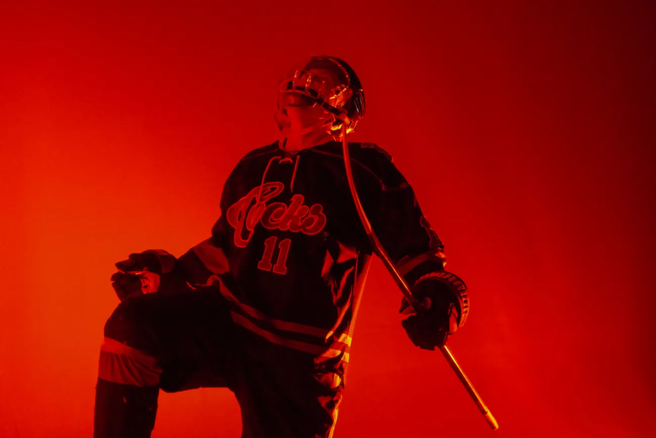 Gamecocks player number 11 with a knee raised and his stick angled down, shot from below