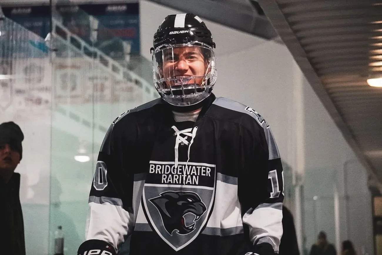 Bridgewater Raritan player grinning behind his cage in the tunnel