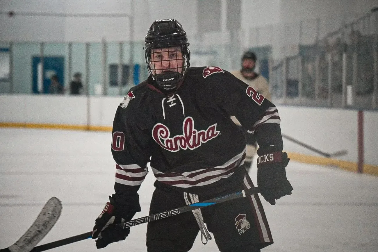 Carolina player skating with his stick up, focused down the ice