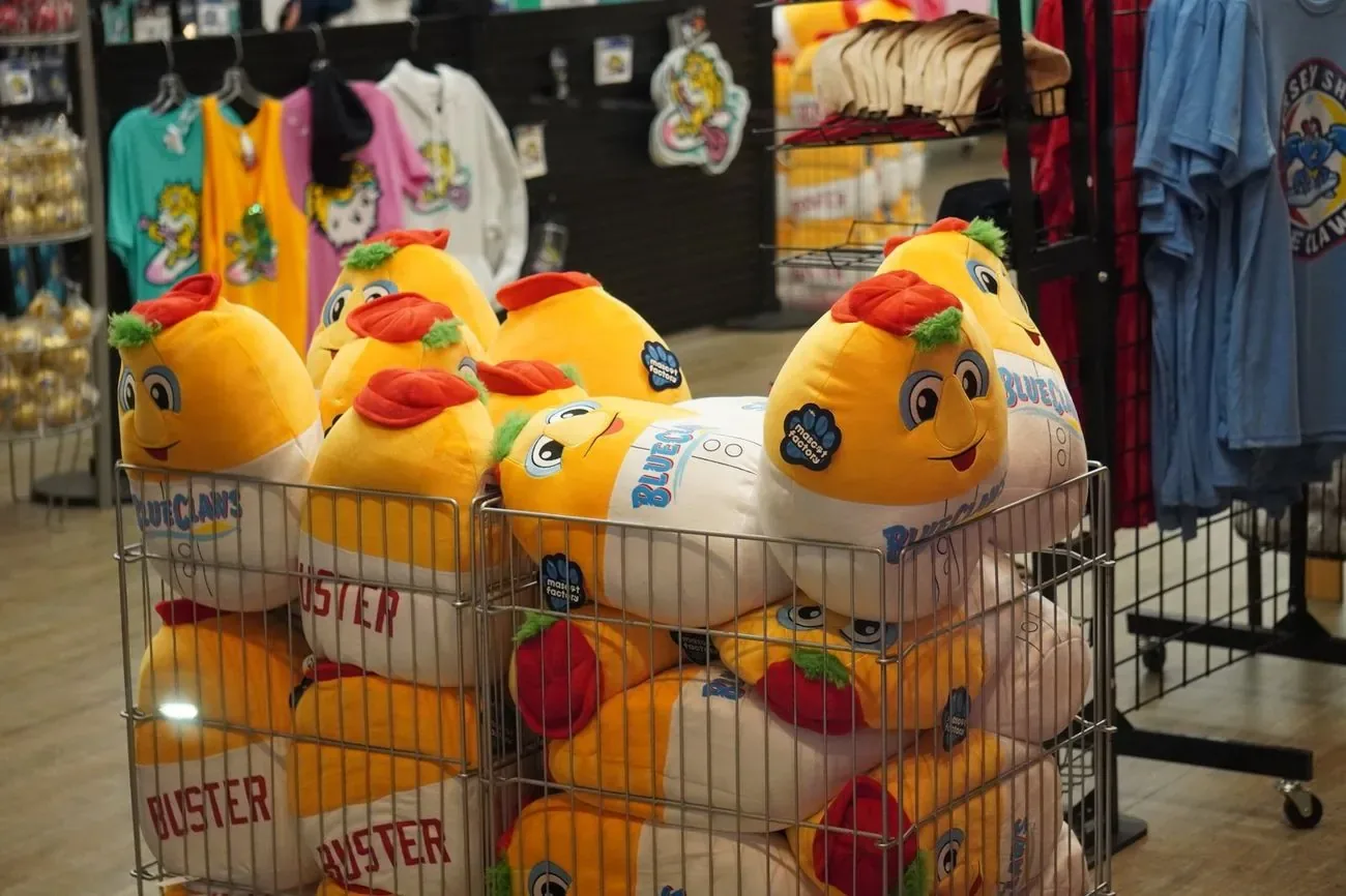 Bin of Buster plush toys in the BlueClaws team store, jerseys racked behind