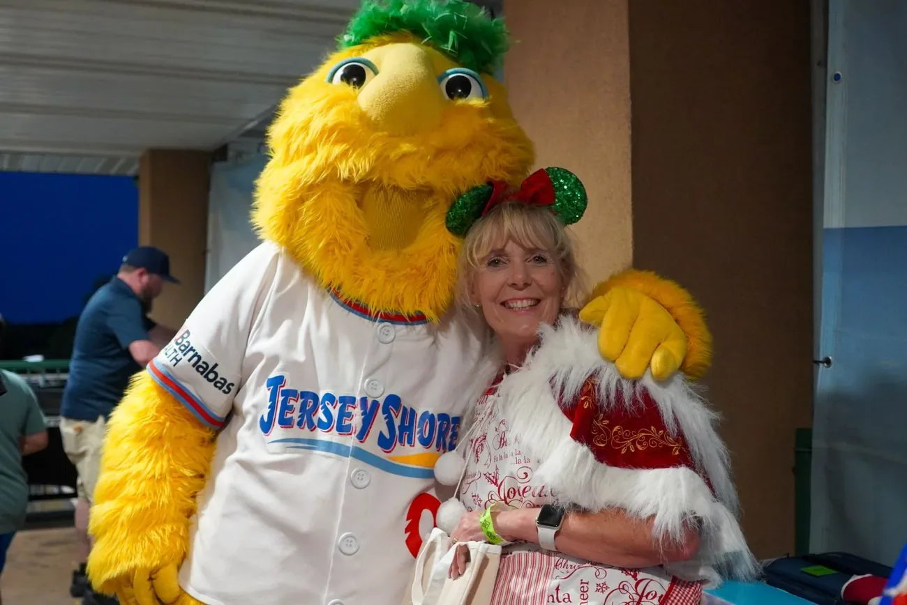 Buster hugging a fan in a red Christmas sweater