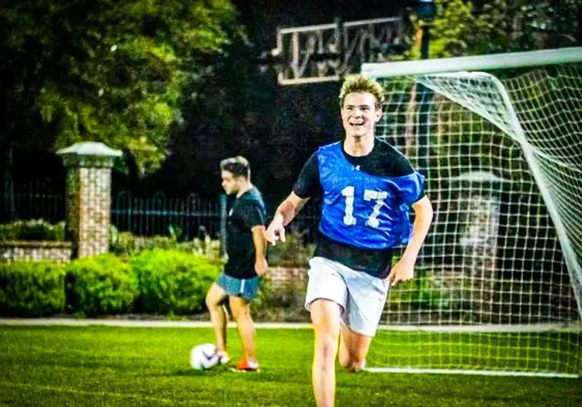 Intramural soccer player in a blue jersey running past the goal