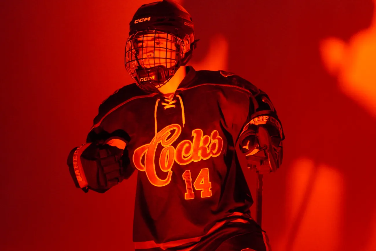 Gamecocks player number 14 stepping toward camera with a glove out, the Cocks script glowing on his jersey