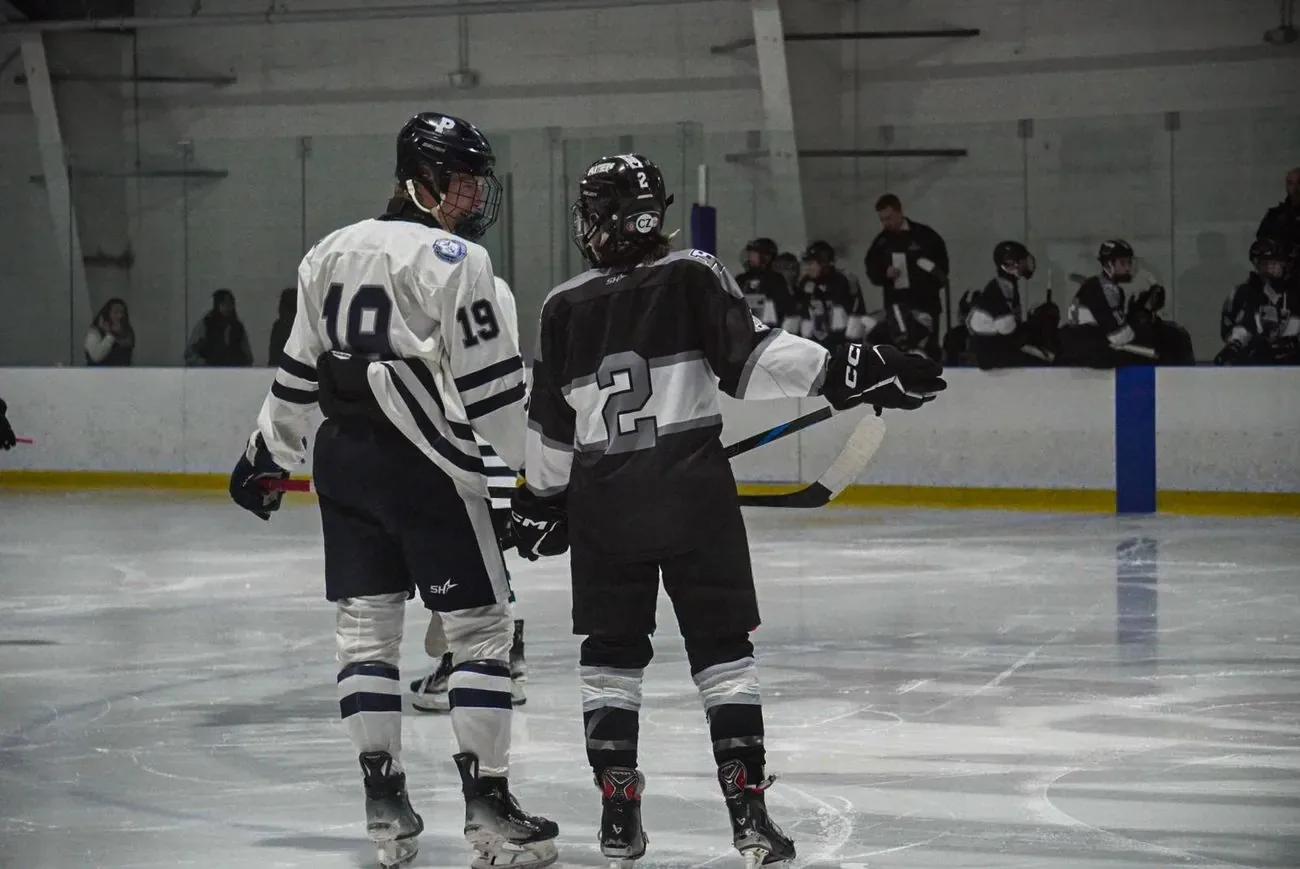 Two players from opposing teams talking during a stoppage in play