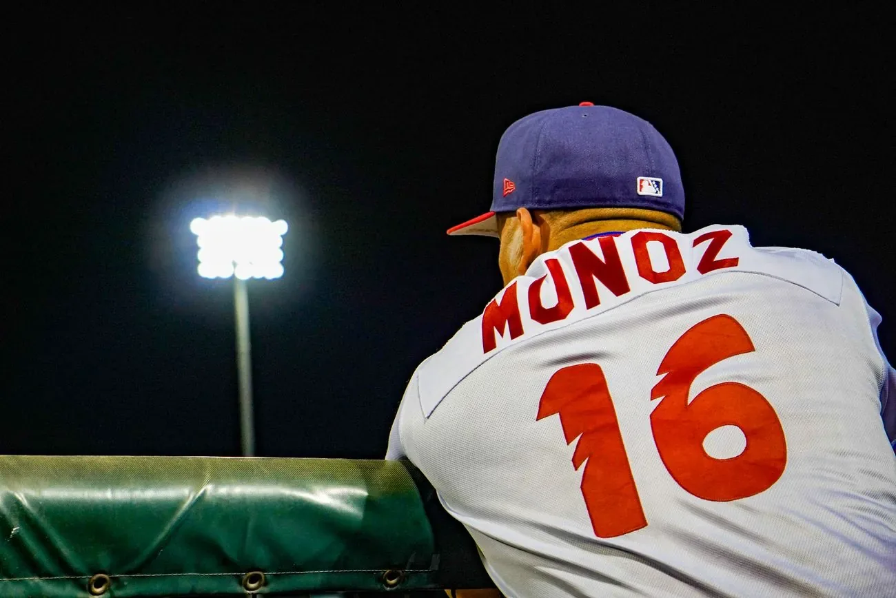 Back of BlueClaws pitcher Munoz, number 16, silhouetted against a stadium light tower at night