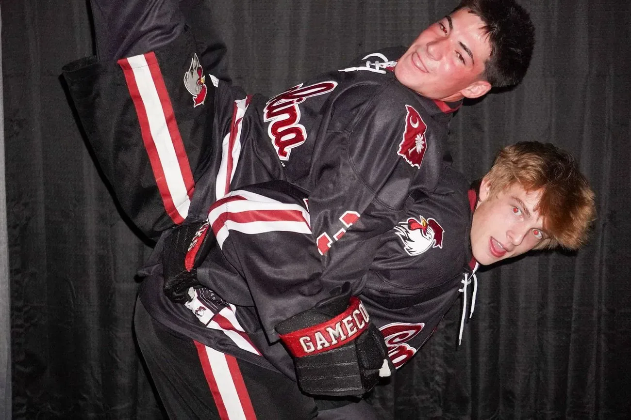 Two Gamecocks players leaning together and laughing after a win