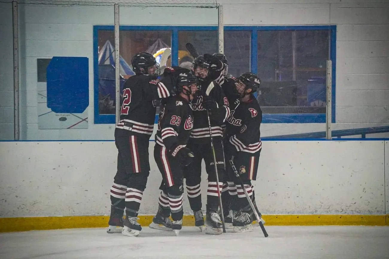 Carolina players huddled together at center ice