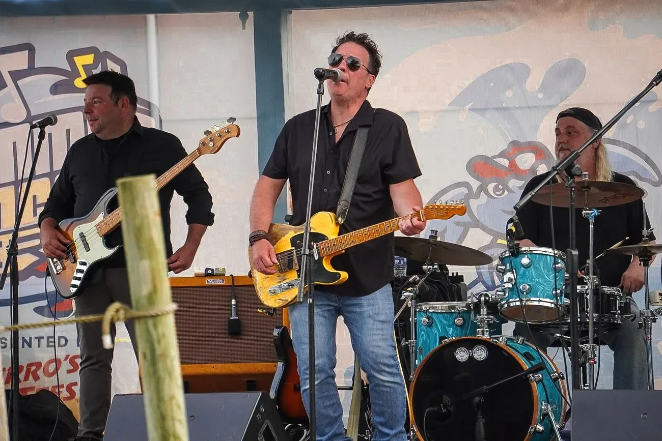 Four-piece band playing a set on stage at the ballpark