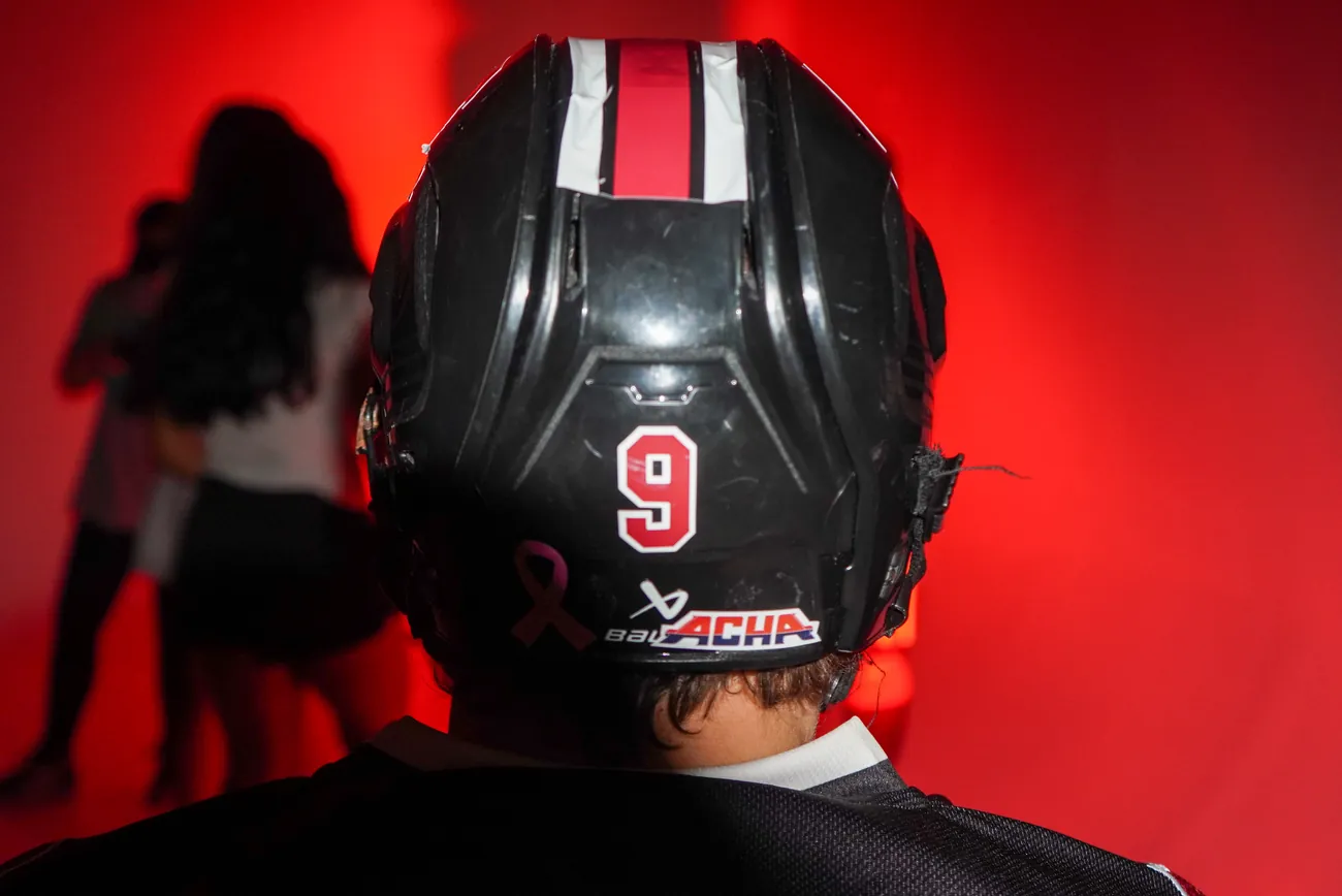 Back of a Gamecocks helmet showing the number 9, an ACHA sticker and a pink ribbon decal