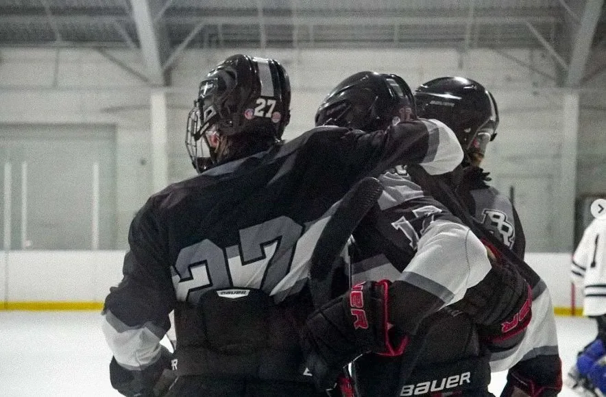 Group hug of Bridgewater Raritan players in dark jerseys after a goal